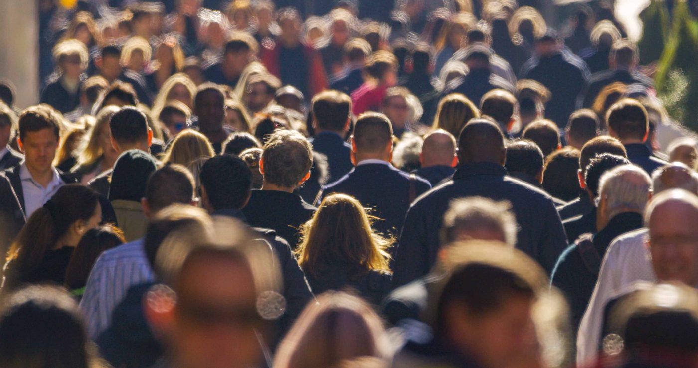 A crowd of professionals on a city street, representing the Seaflux team and partners