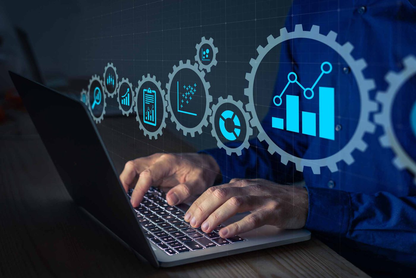 Hands typing on a laptop with logistics data dashboards overlaid